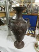 A bronze effect pottery vase with armorial decoration.
