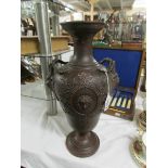 A bronze effect pottery vase with armorial decoration.