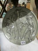 A metal plaque depicting mythical figures.
