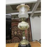 An oil lamp with glass font and later shade.