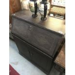 A dark oak bureau with carved front