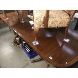 A dark wood stained extending dining table with string inlay and brass lion paw feet