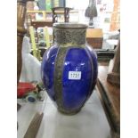 A large blue pottery vase with metal banding.