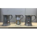 3 armorial metal tankards and a glass example.