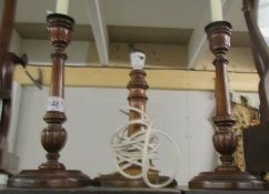 A pair of wooden candlesticks and a wooden table lamp.