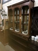 A dark wood stained dresser with multiple bevel edged mirror back