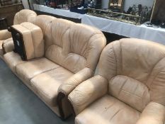 A salmon pink leather 3 piece suite and foot stool