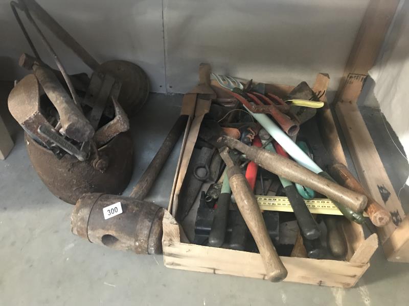 A cast iron sauce pan and contents and a box of tools