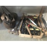 A cast iron sauce pan and contents and a box of tools