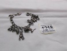 A charm bracelet with 12 silver charms and silver padlock.