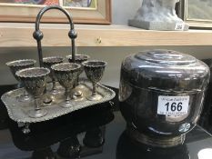 A silver plated egg cup stand and biscuit barrel