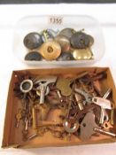 A quantity of old clock keys and pendulums in 2 trays.