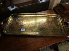 An Indian brass tray engraved with peacocks.