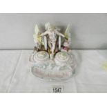A 19th century porcelain ink stand depicting cherub on a winged chariot, 16 cm tall x 19 cm wide.