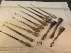 9 silver handled button hooks and 3 silver handled shoe horns.