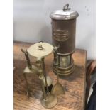 A miners lamp and a small brass fire companion set