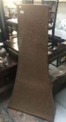 A tall hammered copper fire place chimney front