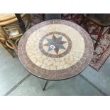 A metal garden table with heavy mosaic top