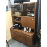 A teak wall unit with glazed top