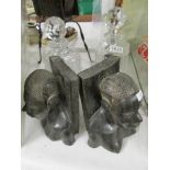 A pair of carved wood African head book ends and 2 cut glass decanters.