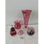 A cut glass cranberry vase, another cranberry vase and 3 glass paperweights.