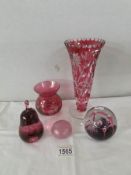 A cut glass cranberry vase, another cranberry vase and 3 glass paperweights.