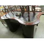 A mahogany curved front desk with green leather inset (leather distressed).