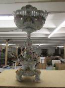 A tall continental porcelain table centrepiece surmounted with musicians and encrusted with flowers.