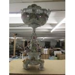 A tall continental porcelain table centrepiece surmounted with musicians and encrusted with flowers.