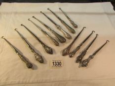 12 silver handled button hooks.