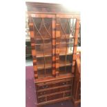 An astragal glazed display cabinet on drawer base