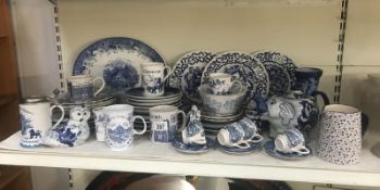 A quantity of assorted blue and white items including plates, mugs, cups and saucers etc.