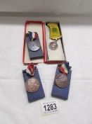 A silver GLE medal and 3 other medals.