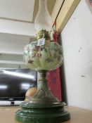 A Victorian oil lamp with hand painted glass font.