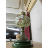 A Victorian oil lamp with hand painted glass font.