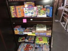 4 shelves of children's games, jigsaws & a quantity of helium balloons etc.