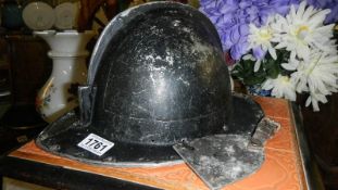 An aluminium fire mans helmet and badge.