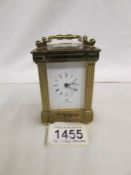 A brass carriage clock by Matthew Norman, 11 jewels, Swiss made with key.