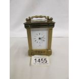 A brass carriage clock by Matthew Norman, 11 jewels, Swiss made with key.