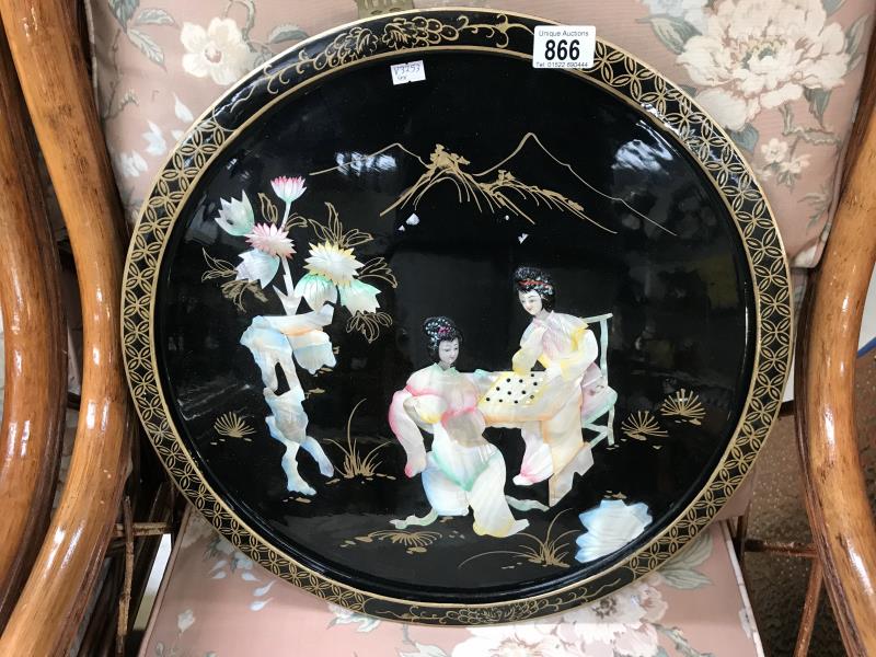 A lacquer and mother of pearl wall plaque of an oriental scene