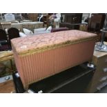 A pink wicker upholstered linen box