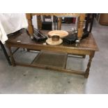 A wood coffee table with woven undershelf