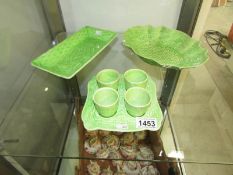 4 green pottery egg cups on tray and 2 dishes.