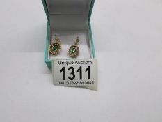 A pair of pearl and green stone pendant earrings in 15ct gold.