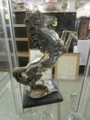 A metal figure of a rearing horse signed A Santini.