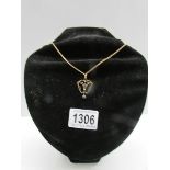 An Edwardian set pendant 9ct gold fashioned as a heart attached to a 9ct gold chain (stamped gold).