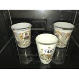 A Victorian crested porcelain beaker and 2 Edwardian enamel beakers.