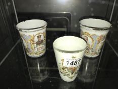 A Victorian crested porcelain beaker and 2 Edwardian enamel beakers.