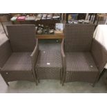 A metal framed plastic woven garden suite of 2 armchairs & a side table