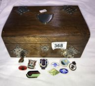 An oak trinket box with shield cartouche including pin badges